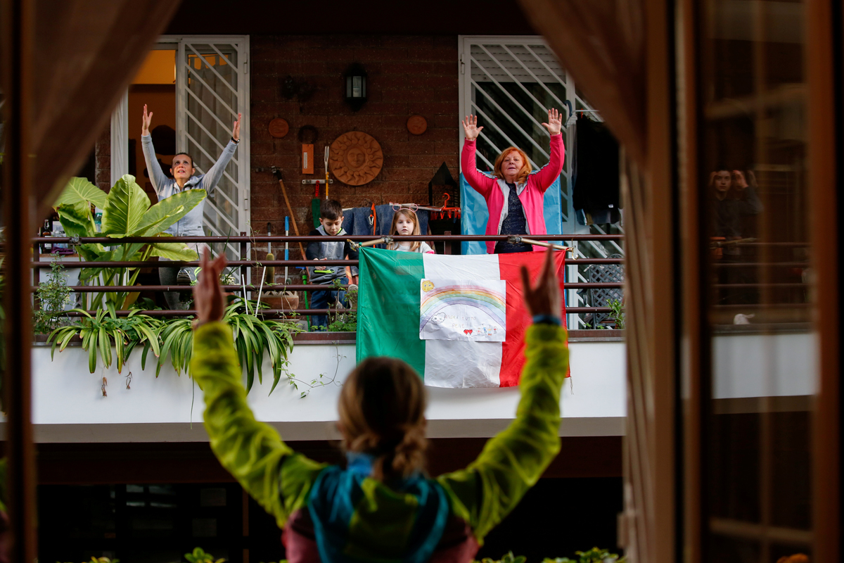 Персональный тренер Антониетта Орсини проводит уроки для своих соседей со своего балкона, в то время как итальянцы не могут покинуть свои дома из-за вспышки COVID-19. Рим, Италия, 18 марта 2020 года