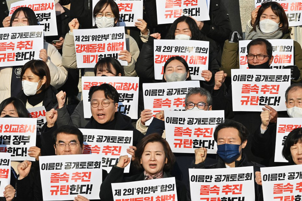 Протестующие держат плакаты с надписью «Мы выступаем против унизительного решения правительства Юн Сок Ёля относительно проблемы принудительного труда!», Сеул, 12 января 2023 год