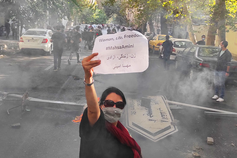 Женщина держит записку с надписью «Женщина, жизнь, свобода, #МахсаАмини» во время протестов. Тегеран, 1 октября 2022 год