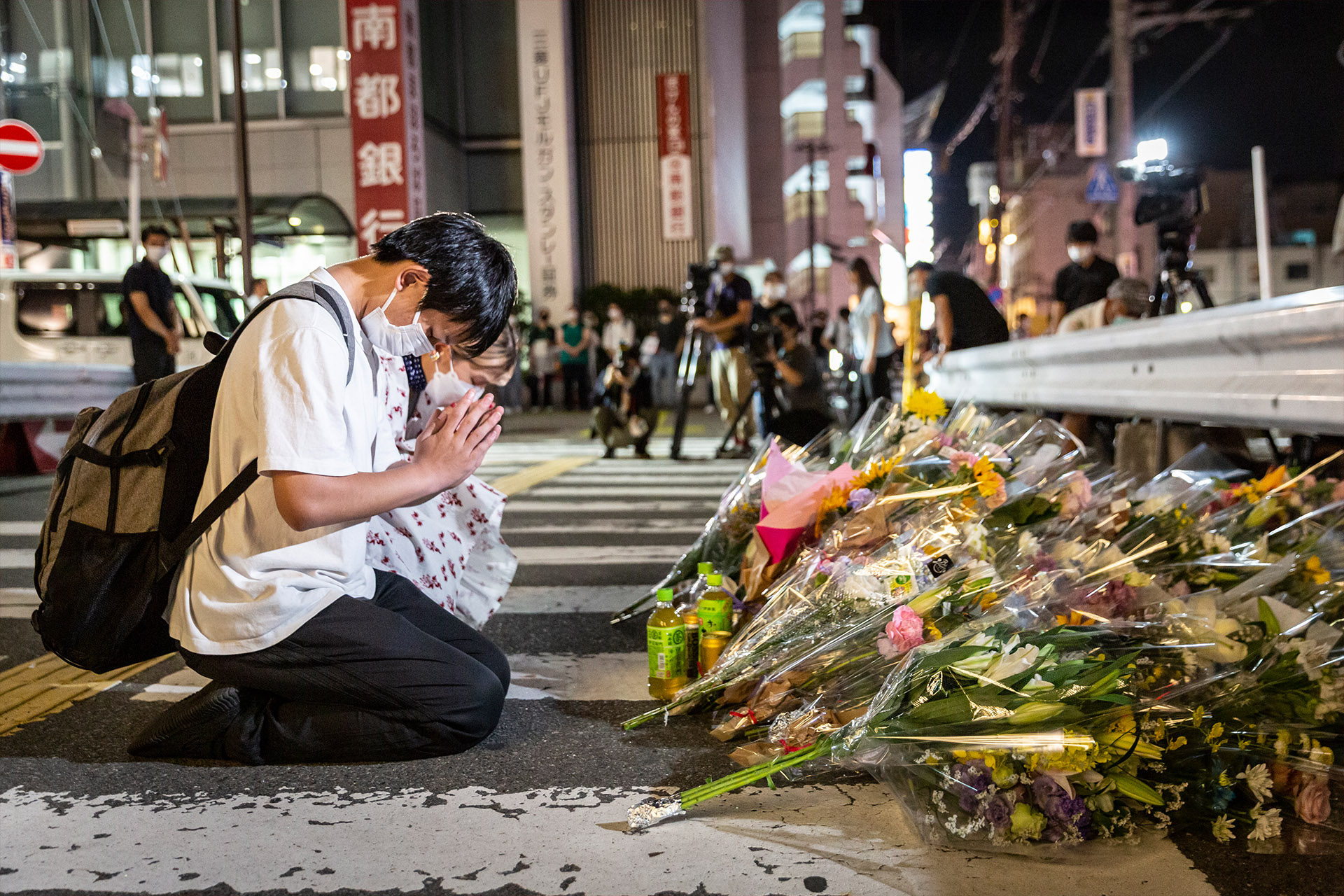 Люди молятся на месте возле станции Ямато-Сайдайдзи, где был застрелен бывший премьер-министр Японии Синдзо Абэ