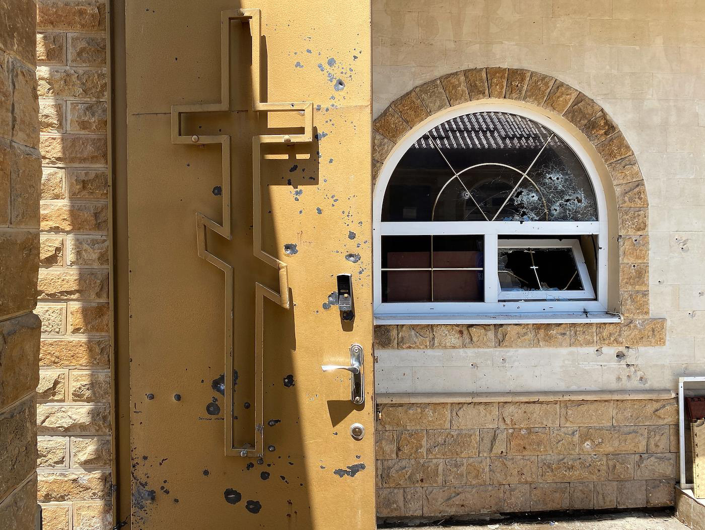 Следы пуль на двери и оконном стекле здания Свято-Успенского собора в Махачкале