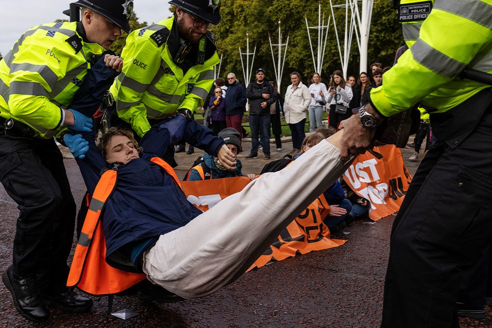 Полицейские задерживают активистку движения  Just Stop Oil возле Букингемского дворца, Лондон,  10 октября 2022 год