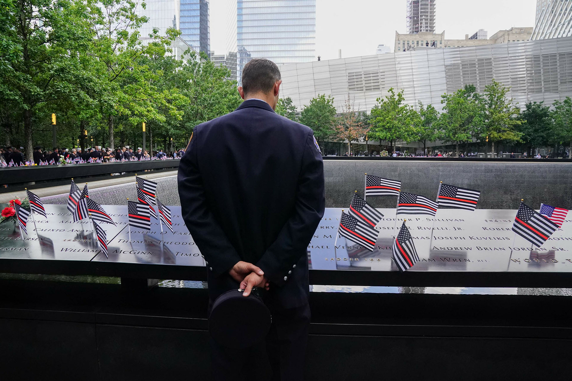 Нью-йоркский пожарный смотрит на имена в мемориальном бассейне 9/11 в 22-ю годовщину террористической атаки на Всемирный торговый центр в Нью-Йорке, 11 сентября 2023 года