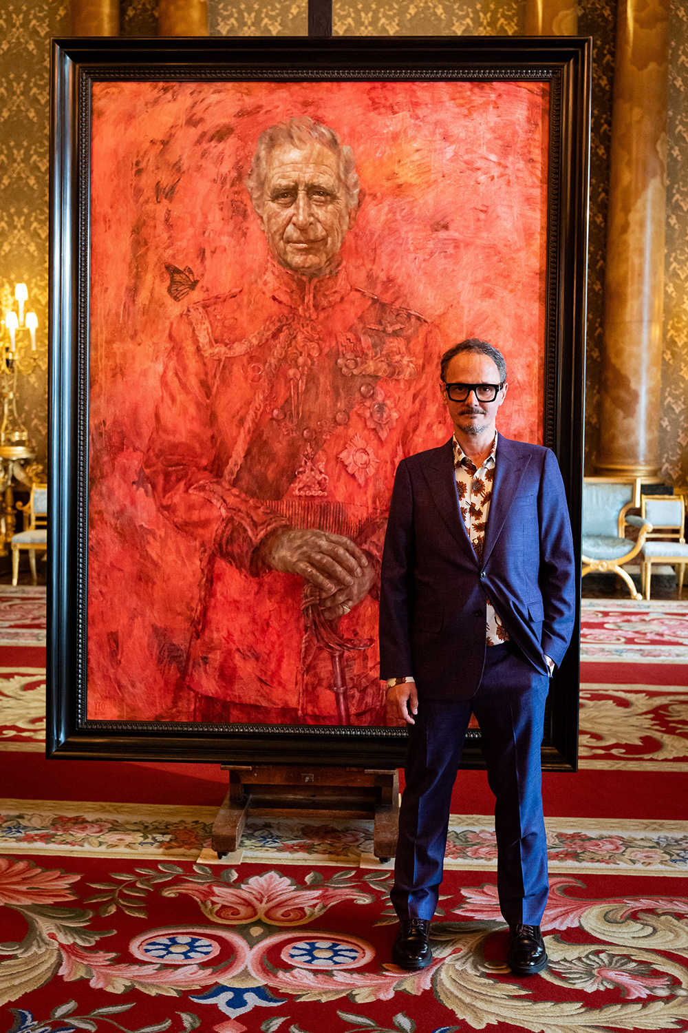 Художник Джонатан Йео на фоне портрета Карла III