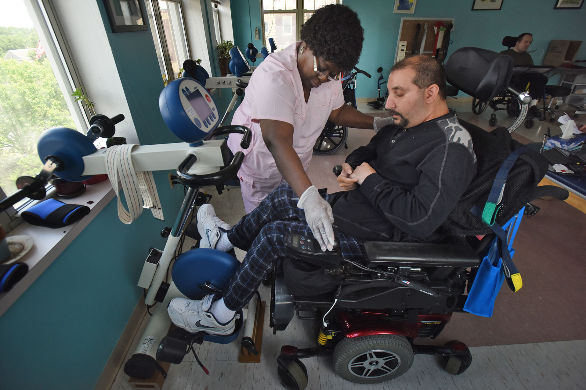 Пациент с рассеянным склерозом занимается на тренажёре, помогающем ему передвигать ноги