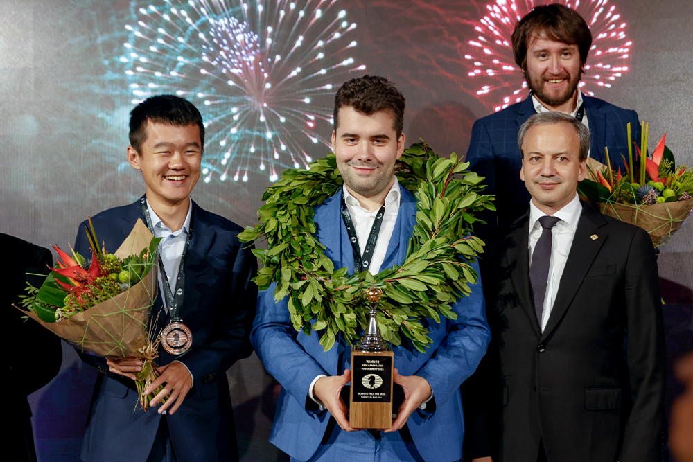 Дин Лижэнь (слева) и  Ян Непомнящий (в центре) во время церемонии закрытия турнира по шахматам FIDE в Мадриде, Испания. 5 июля 2022 года
