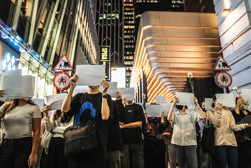 Демонстранты держат пустые плакаты во время акции протеста. Гонконг, 28 ноября 2022 год
