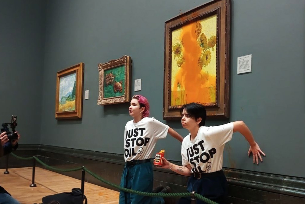Активистки движения Just Stop Oil возле картины Ван Гога «Подсолнухи» в лондонской Национальной галерее, 14 октября 2022 год