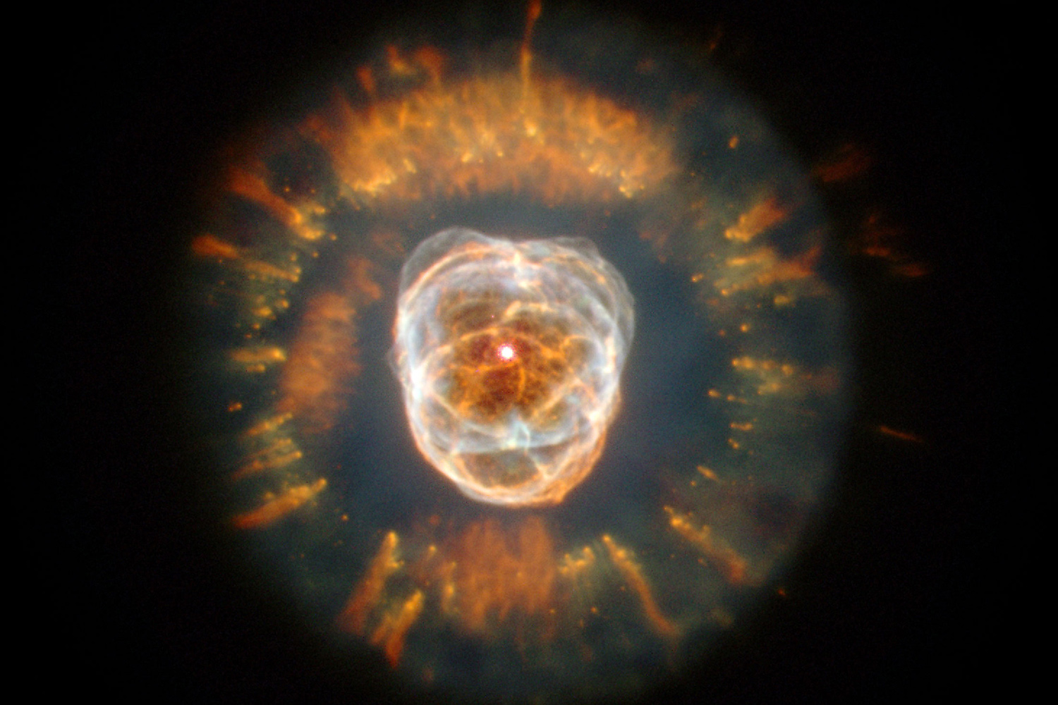 NGC 2392 — планетарная туманность Эскимос. Расположена совсем рядом: всего 3 тысячи световых лет от Земли. Ее открыл в 1787 году Уильям Гершель. 223 года спустя «Хаббл» получил первый детализованный снимок Эскимоса. Внешняя туманность образовалась примерно 10 тысяч лет назад, внутренние нитевидные структуры — совсем недавно, не больше 3-4 тысяч лет назад